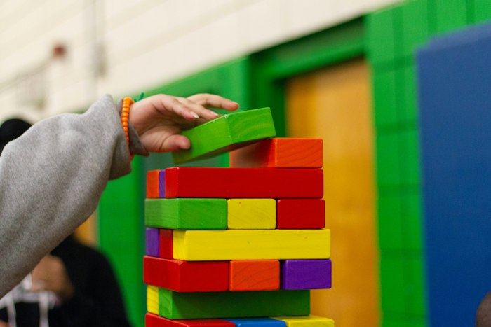 Torre de blocos coloridos montada por mãos infantis